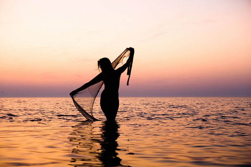 Nackte Frau mit einem Fischernetz bei Sonnenuntergang im Wattenmeer von Arjan Groot