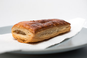 A sausage roll just out of the oven.