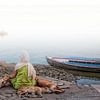 Diese Frau meditierte an den Ufern des Ganges in Varanasi in Indien, wenn einige streunender Hunde z von Wout Kok