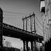 Manhattan Bridge tussen de Gebouwen – Zwart-Wit New York van Thea.Photo
