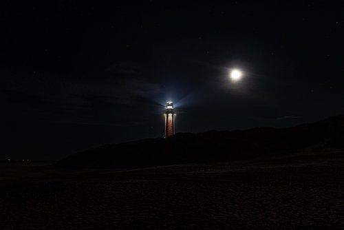 Avec la lune à côté du phare depuis la plage.