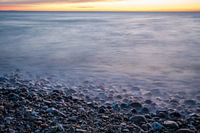 Zee en strand en zonsondergang
