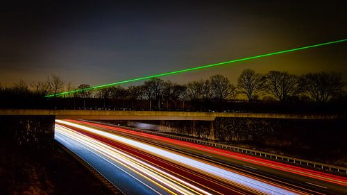 Laserlicht boven de snelweg. Long exposure opname van Twan van den Hombergh