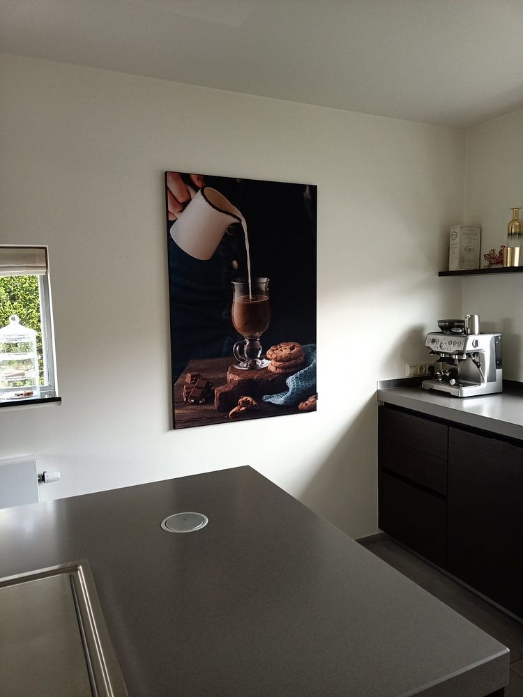 Frau gießt Milch in Glas mit Kaffee ein  von Iryna Melnyk 