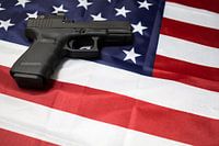 Closeup of gun on the American flag.