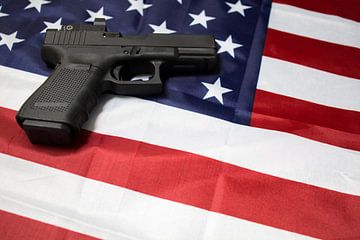 Closeup van pistool op de Amerikaanse vlag. van N. Rotteveel