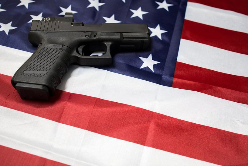 Closeup of gun on the American flag. by N. Rotteveel