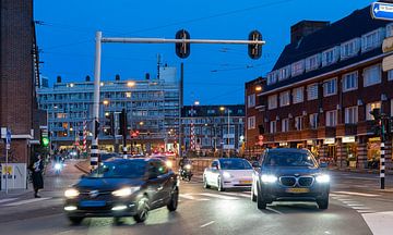 Blauwe hemel na zonsondergang geeft een speciale sfeer aan stadstraat, overal branden lichten, het verkeer trekt op van Jan Willem de Groot Photography