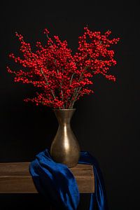 Stilleven met rode ilex bessen in een bronzen vaas