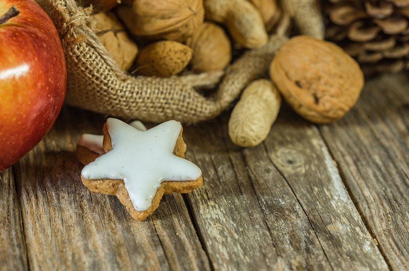 Kerstmaaltijd op tafel, noten, appel en stervormig koekje van Alex Winter
