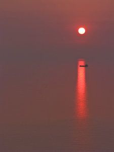 Bateau cargo au coucher du soleil sur Rene van der Meer