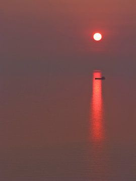 Vrachtboot bij ondergaande zon van Rene van der Meer