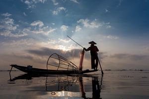 VISSER OP TRADITIONELE MANIER BIJ ZONSOPGANG AAN HET WERK OP HET