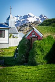 Icelandic Turf House with Red Façade and Snowy Mountain von Patrick Kilb