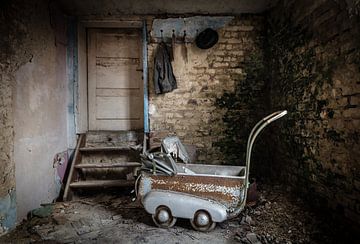 Baby carriage in abandoned house by Inge van den Brande