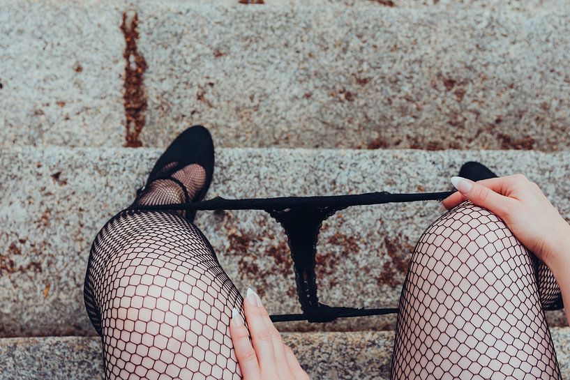 Frau sitzt in sexy schwarzen Netzstrümpfen und High Heels mit Höschen von Denny Gruner
