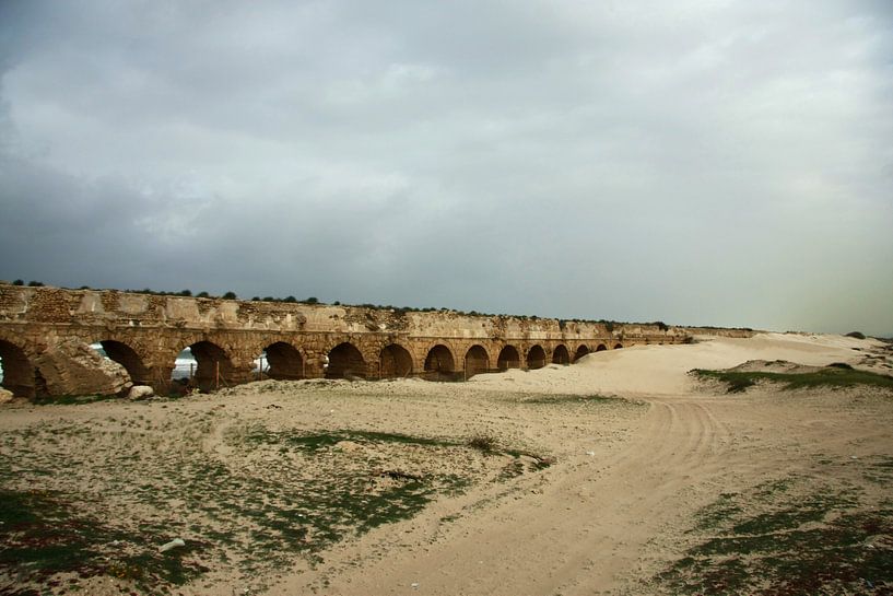Les ruines d'un ancien aqueduc romain sont recouvertes de sable à Césarée (Israël), sous un ciel d'h par Michael Semenov