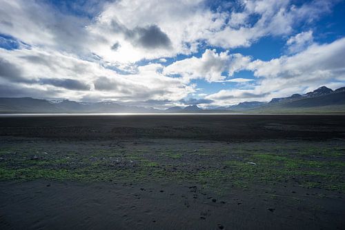 Islande - Paysage infini de sable noir entre des montagnes enneigées