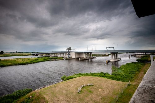 Dark storm clouds over modern bridge in a Dutch landscape