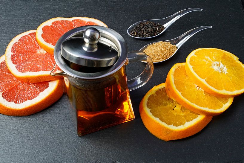 Zwarte thee in een pot, versierd met schijfjes grapefruit en sinaasappel van Babetts Bildergalerie