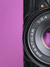 Macro close-up van detail van vintage  'Praktica' camera met paarse achtergrond. van Iris Koopmans