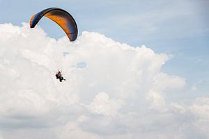 Paraglider vliegend voor een bewolkte lucht van Joep van de Zandt