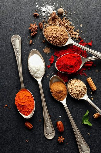 Kleurrijke kruiden op lepels