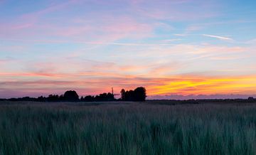 Landschap, molen in weiland bij  zonsondergang van Marcel Kerdijk
