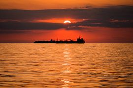 Sunset at sea over ships by Jan Georg Meijer