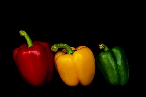 Stilleven macro peper rood geel groen op zwart