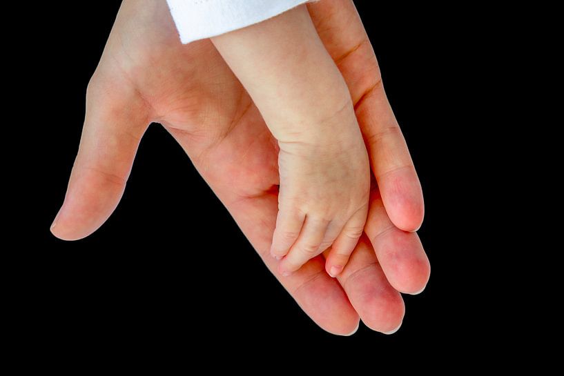 Hand of mother carrying arm of baby on black background by Ben Schonewille