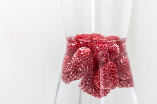 Stillleben Himbeeren und Wasser im Wasserkrug