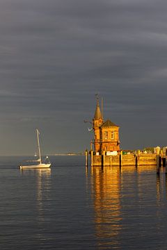 Constance sur le lac de Constance, entrée du port avec phare, bateaux, reflets au coucher de soleil orange sur Andreas Freund