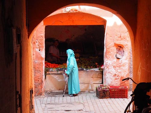 Morocco; woman in alley caught in heavenly light.