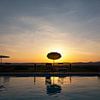 Een zonsondergang met zwembad en blauw water in, Toscane, Italië. van Tjeerd Kruse