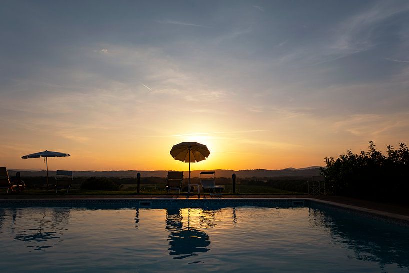 Een zonsondergang met zwembad en blauw water in, Toscane, Italië. van Tjeerd Kruse