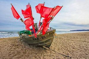 Bateau de pêche avec drapeaux rouge vif sur l'île de Rügen