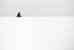 Een zeilschip zeilt aan de horizon ver op een kalme en rustige zee