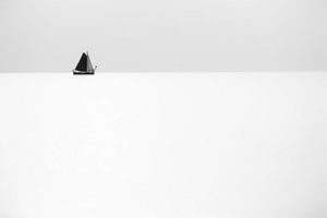 Ein Segelschiff segelt weit am Horizont auf ruhiger und stiller See