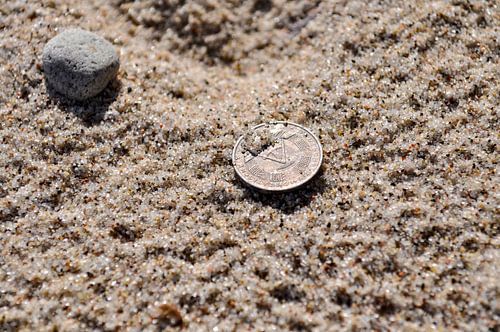DDR Münze im Sand