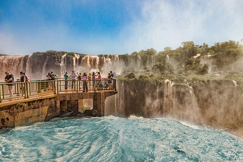 Mensen op een loopbrug in het midden van de Iguazu watervallen bij