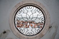 Zicht op Lissabon door een raam met gietijzer motief