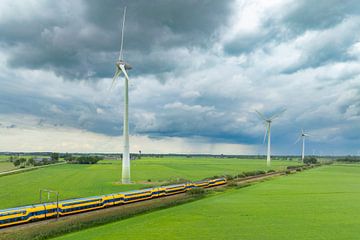 Trein van de Nederlandse Spoorwegen rijdt langs windturbines van Sjoerd van der Wal Fotografie