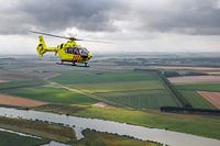 Traumahelikopter boven typisch Nederlands landschap