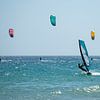 Surfer en kite surfers op zee bij Tarifa, Spanje. van Monique van Helden