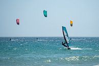 Surfer en kite surfers op zee bij Tarifa, Spanje. van Monique van Helden thumbnail