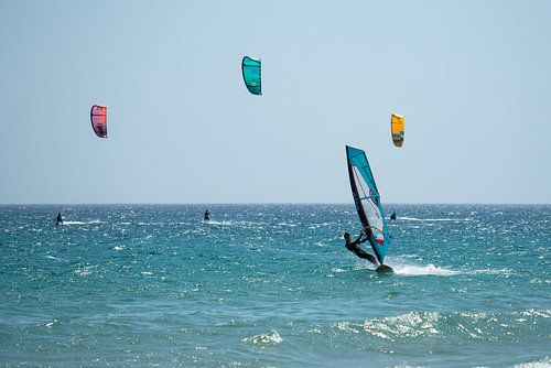 Surfeur et kite surfers en mer près de Tarifa, Espagne.