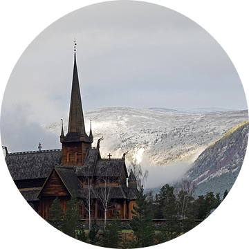 Staafkerk van Lom in Noorwegen met besneeuwde bergen op de achtergrond. van Aagje de Jong