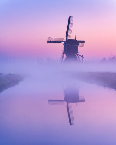 Molen in de mist tijdens zonsopkomst