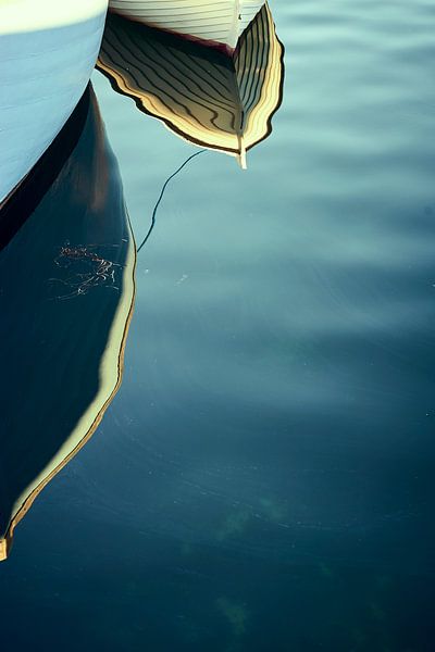 Der Bug eines kleinen Fischerboots spiegelt sich im Wasser von Michael Moser